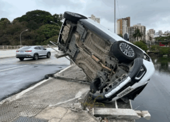 Médica fica ferida em acidente a caminho do trabalho em Vitória; Carro da vítima pendurado em ponte